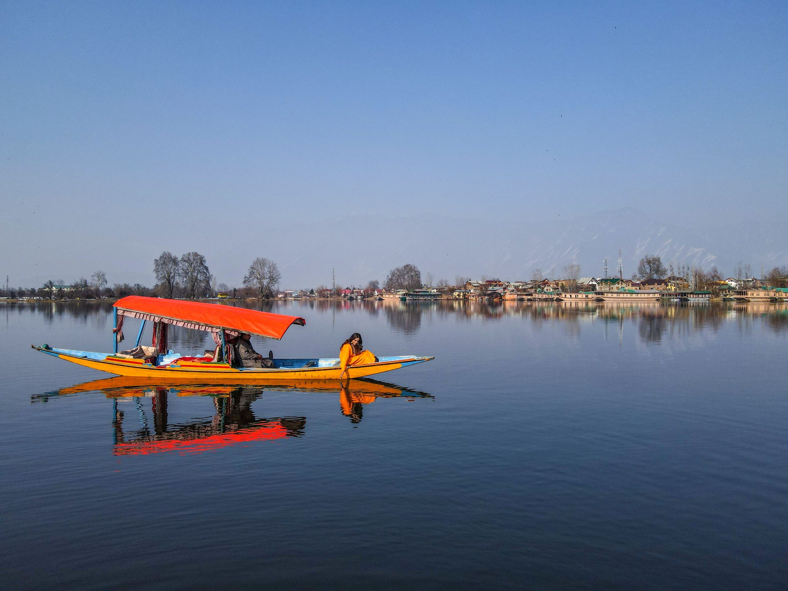 Colorful shikara boat with woman on Dal Lake Colorful shikara boat with woman on Dal Lake